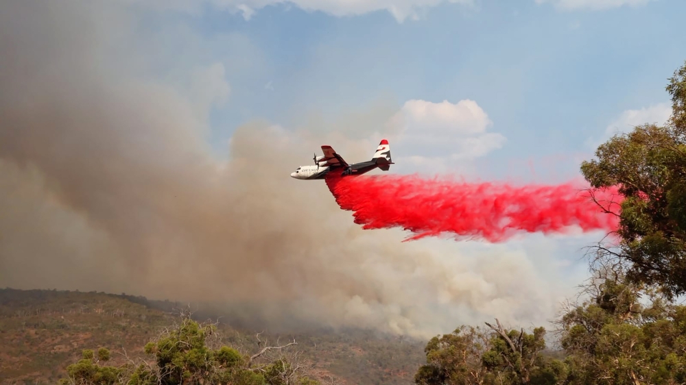 A photo provided by the Department of Fire and Emergency Services of a plane spreading fire retardant near Wooroloo, Australia
