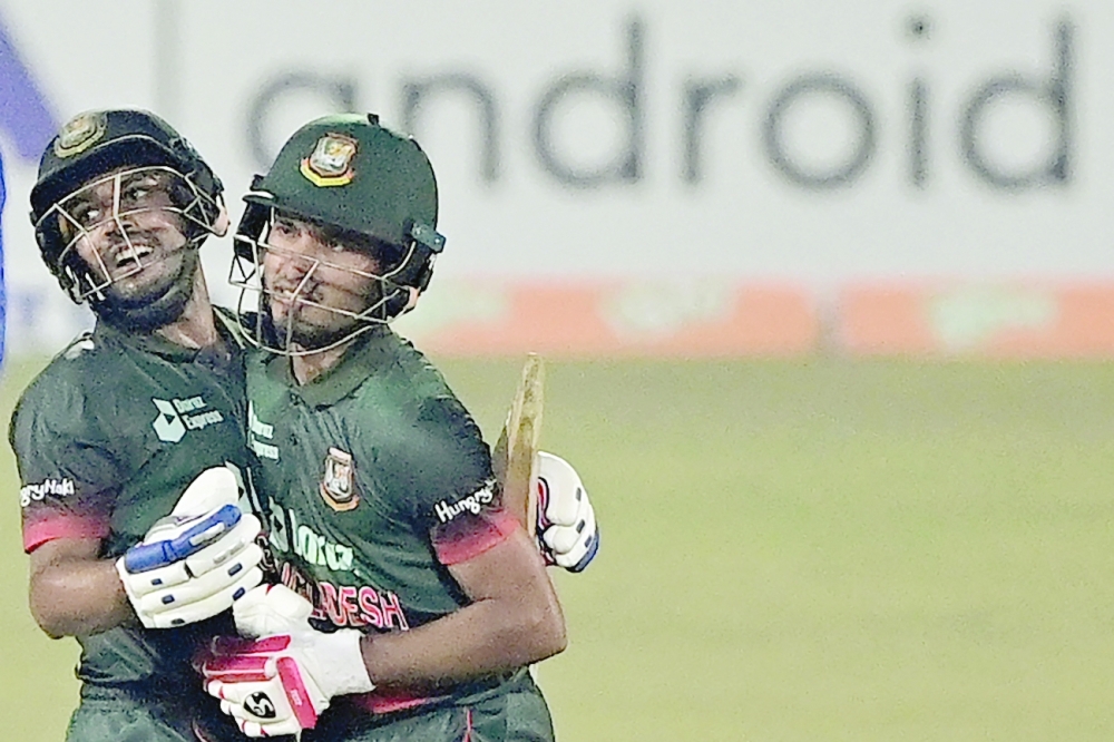 Bangladesh's Mehidy Hasan Miraz (R) with teammate Afif Hossain celebrate their win at the end of play during the first one-day international (ODI) cricket match between Afghanistan and Bangladesh at the Zahur Ahmed Chowdhury Stadium in Chittagong on February 23, 2022.  (Photo by Munir uz ZAMAN / AFP)

