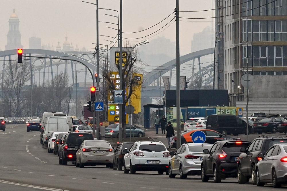 People queue to a petrol station in Kyiv on February 24, 2022. 
