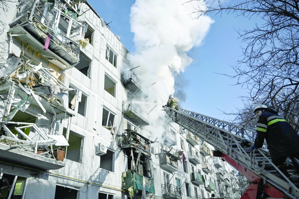 Firefighters try to put out a blaze on a building after bombings on the eastern Ukraine town of Chuguiv on Thursday, as Russian armed forces are trying to invade Ukraine from several directions, using rocket systems and helicopters to attack Ukrainian position in the south, the border guard service said. - AFP 