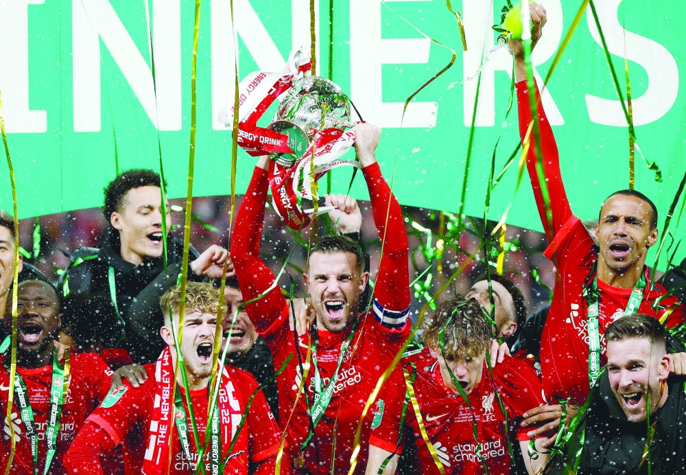Liverpool's Jordan Henderson lifts the trophy as they celebrate winning the Carabao Cup. -- Reuters