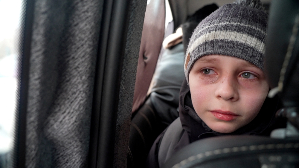 Mark Goncharuk, a young boy from Kyiv, reacts as he talks about leaving his father behind