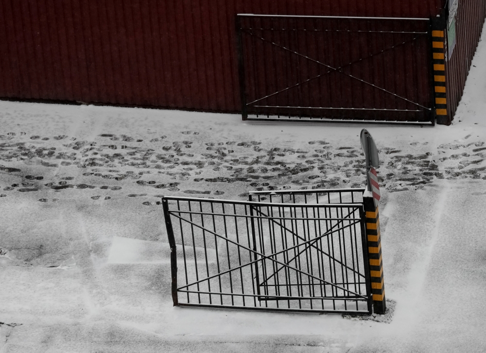 Footprints are seen on the snow near the entry of a food store in Kyiv