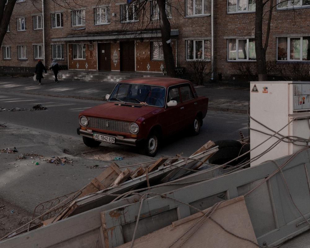 A car is parked next to a street barricade in Kyiv