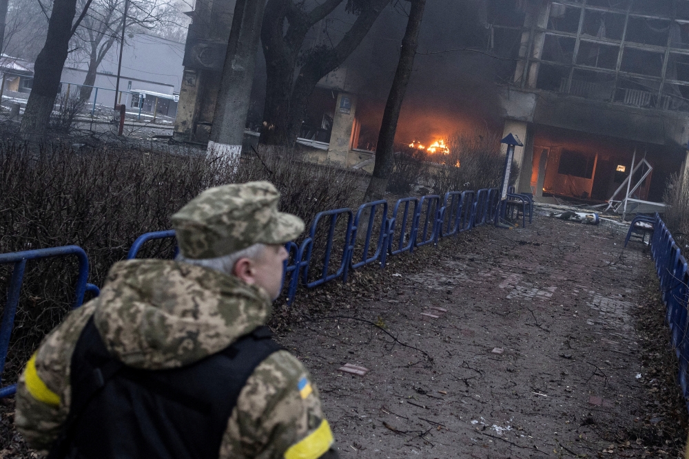 A member of the military walks near a building after a blast, amid Russia's invasion of Ukraine, in Kyiv