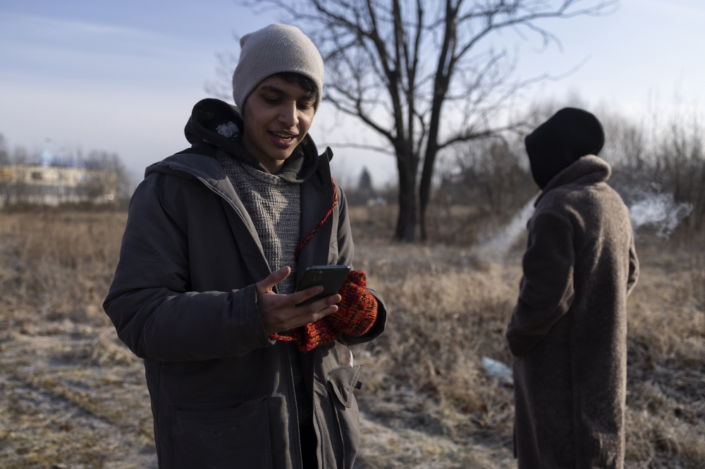 Mohammed Amin, a pharmacy student in Dnipro, Ukraine, calls his family in Morocco from a makeshift reception center in Przemysl, Poland, on Tuesday, March 1, 2022. (Maciek Nabrdalik/The New York Times)