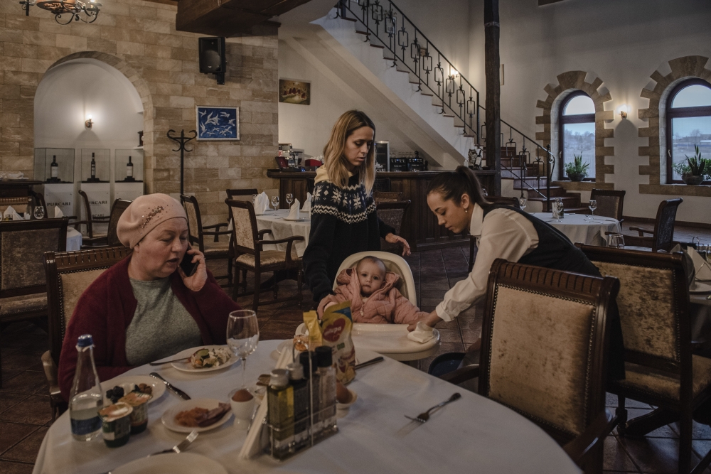 Julia Kondrativa, standing, with her daughter, Sonja, and her mother, Valentina at a winery hotel in Purcari, Moldova, where they had fled to from Ukraine, March 1, 2022. (Laetitia Vancon/The New York Times)