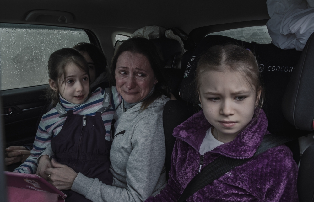 Ilona Koval, from Odessa, weeps as she traveled together with some of the girls she trained as figure skaters, at a temporary refugee camp on the Ukrainian border in Palanca, Moldova, March 1, 2022. (Laetitia Vancon/The New York Times)