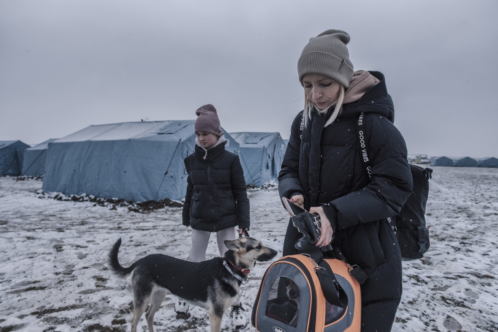 Svetlana Tomashevscaia and her daughter Monica, 12, with their two dogs at a temporary refugee camp in Palanca, Moldova on March 1, 2022. (Laetitia Vancon/The New York Times)