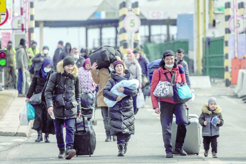 Refugees from Ukraine are seen as they arrive at the border crossing in Korczowa, Poland. - AFP 
