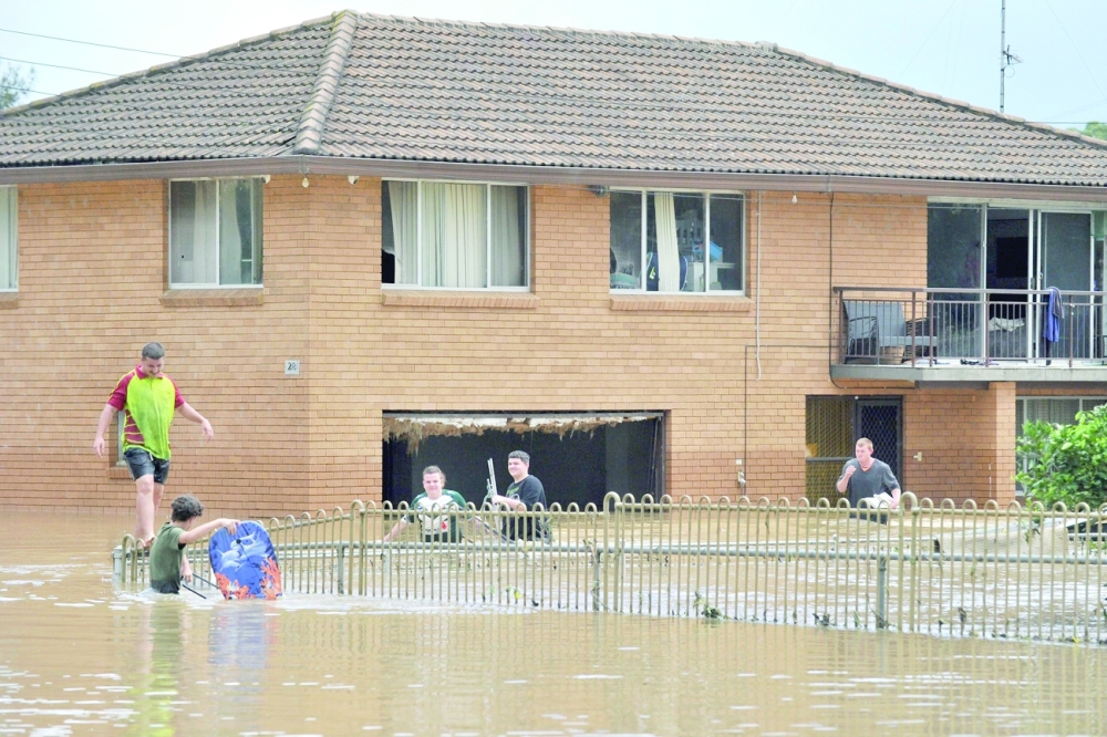Residents remove their belongings from their flooded home in western Sydney as the area faces its worst flooding after record rainfall caused its largest dam to overflow. -- AFP
