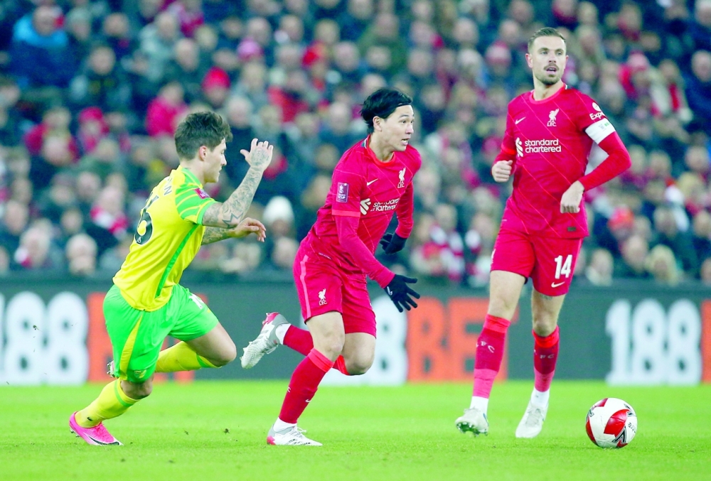 Liverpool's Takumi Minamino and Jordan Henderson in action with Norwich City's Mathias Normann. -- Reuters