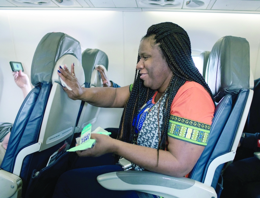 Alicia Smith cleans her surroundings on an American Airlines flight to Washington from Detroit Metropolitan Wayne County Airport in Romulus, Mich., Tuesday, March 3, 2020. (Alyssa Schukar/The New York Times)