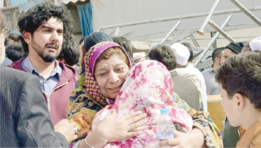 Relatives mourn the death of their relatives outside a hospital following a bomb blast at a mosque in Peshawar. -- AFP