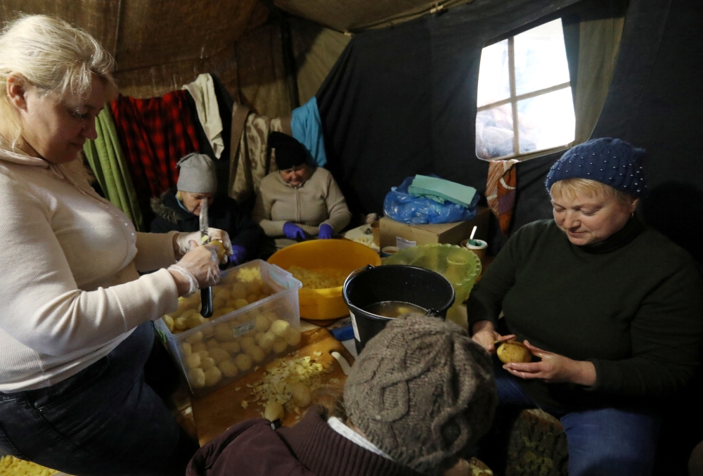 Women prepare food for local residents and members of the Territorial Defence Forces at a field kitchen in Kyiv