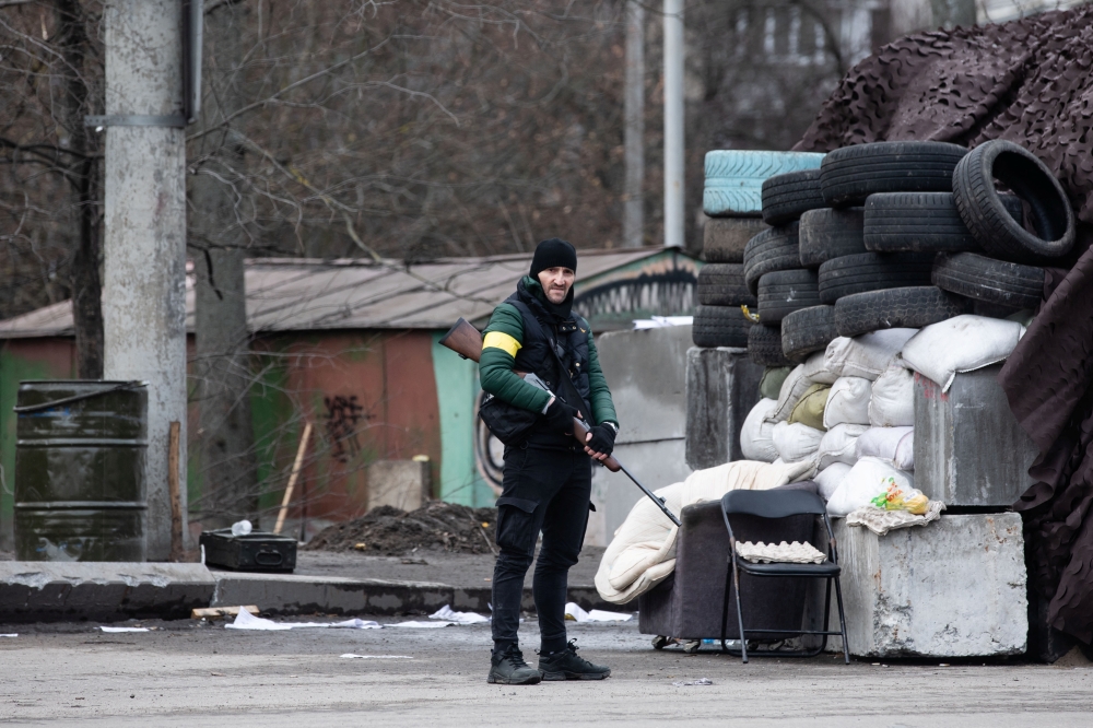 Members of Ukraine's Territorial Defence Forces stand guard at a checkpoint in Kyiv