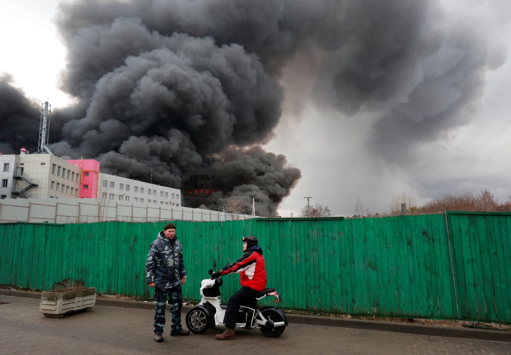 Smoke billows from a warehouse and an office building which, according to local authorities, caught fire after shelling, in the Kyiv region
