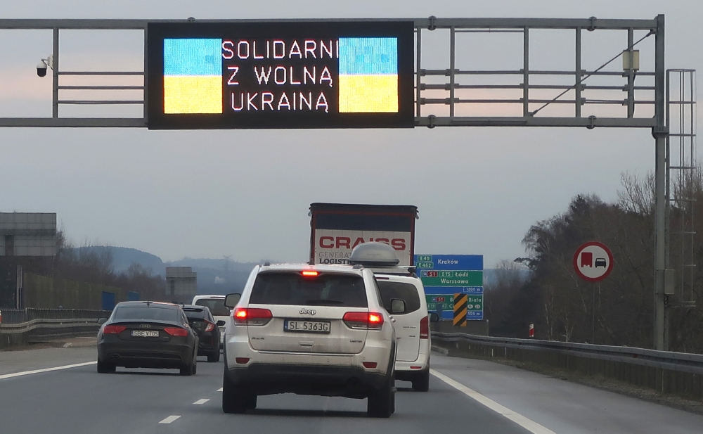 Cars pass on a high way under a display in Krakow area