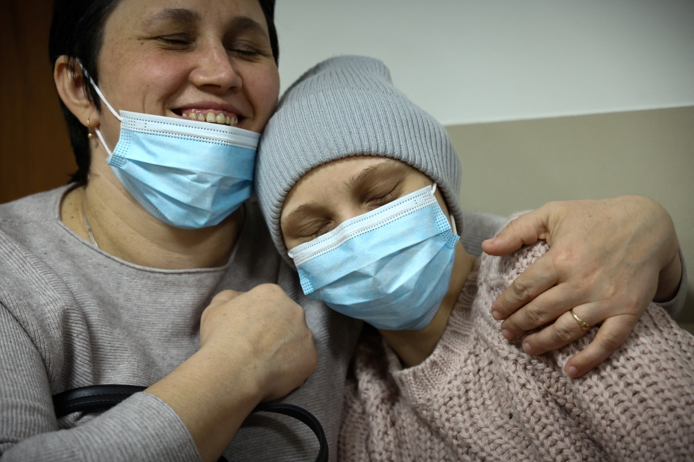 Ukrainian Alinka and her mother Katya wait outside the examination room of children's oncology ward at the Institute of Mother and Child hospital, in Warsaw