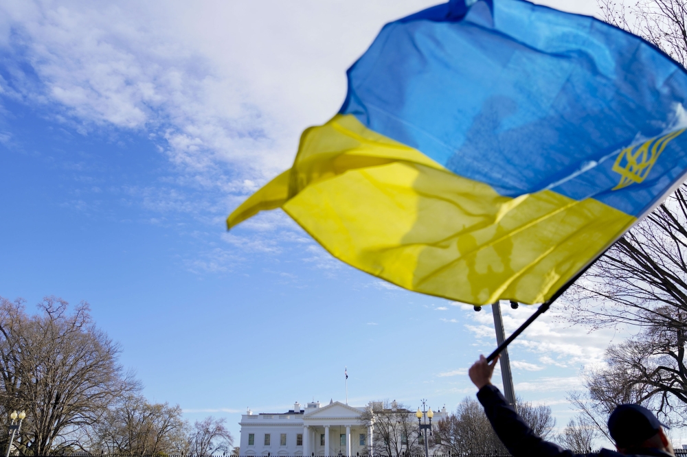 A demonstrator waves the Ukrainian flag outside the White House, in Washington, Tuesday, March 1, 2022. (Leigh Vogel/The New York Times)