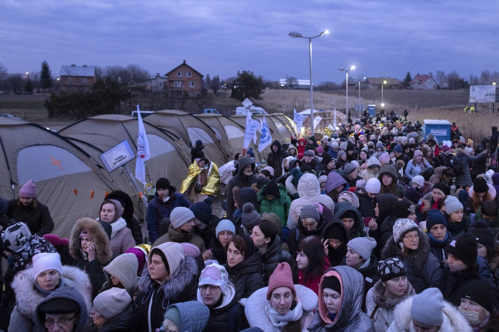 Refugees from Ukraine wait for a bus to continue their journeys after crossing the Polish border to Medyka, on Monday, March 7, 2022. (Maciek Nabrdalik/The New York Times)