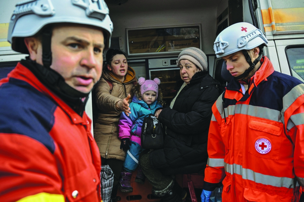 Members of the Red Cross help people who flee the city of Irpin, west of Kyiv. - AFP