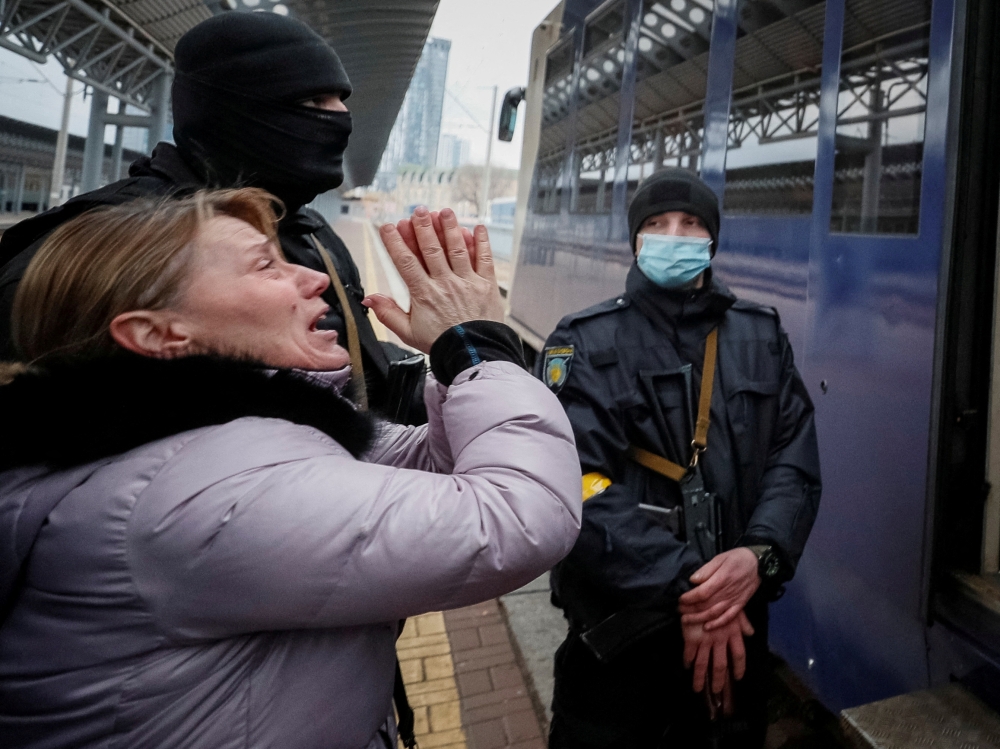 A woman reacts at Kyiv central train station in Kyiv