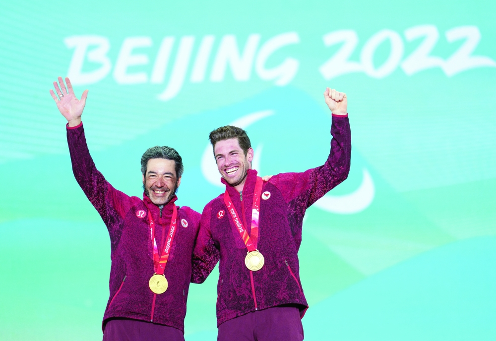 Beijing 2022 Winter Paralympic Games - Para Cross-Country Skiing - Men's Long Distance Classical Technique Vision Impaired - Zhangjiakou Medal Plaza, Zhangjiakou, China - March 7, 2022. Gold Medallist Brian McKeever of Canada and his guide Russell Kennedy pose with their medals during the medal ceremony. Thomas Lovelock/OIS/Handout via REUTERS
