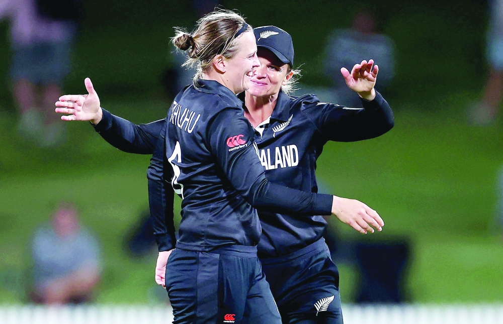 New Zealand's Lea Tahuhu (L) celebrates the wicket of India's Sneh Rana with teammate Suzie Bates during the 2022 Women's Cricket World Cup match between New Zealand and India at Seddon Park in Hamilton on March 10, 2022. (Photo by Marty MELVILLE / AFP)

