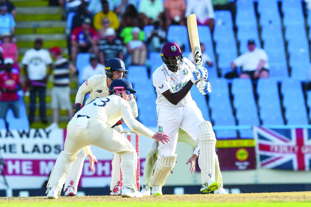 Jason Holder (R) of West Indies plays defensive during the 2nd day of the 1st Test between England and West Indies at Vivian Richards Cricket Stadium in North Sound, Antigua and Barbuda, on March 9, 2022.  (Photo by Randy Brooks / AFP)

