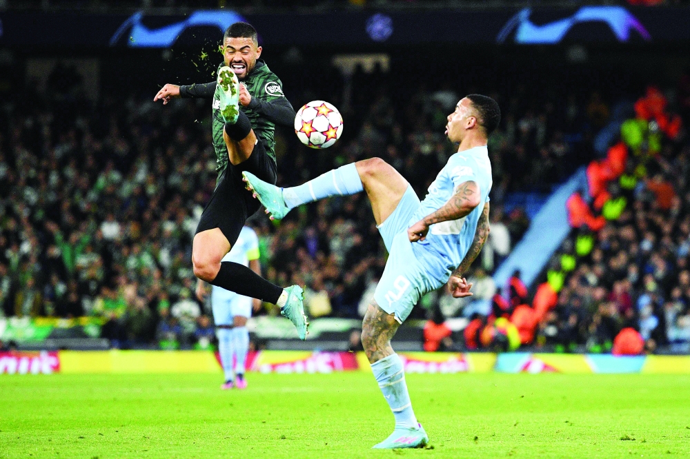 TOPSHOT - Sporting Lisbon's Brazilian sriker Bruno Tabata (L) vies with Manchester City's Brazilian striker Gabriel Jesus during the UEFA Champions League round of 16 second leg football match between Manchester City and Sporting Lisbon at the Etihad Stadium in Manchester, north west England, on March 9, 2022. (Photo by Oli SCARFF / AFP)