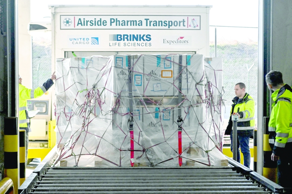 Airport staff handle packages during a press visit dubbed ‘One billion vaccines transported via Brussels Airport’ on Thursday. One billion Covid-19 vaccines have been handled at the airport since November 2020. — AFP