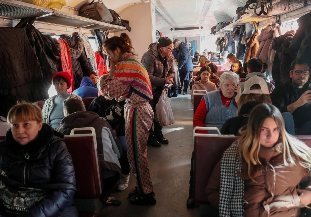 People are seen sitting and standing in an evacuation train from Kyiv to Lviv, at Kyiv central train station, in Kyiv