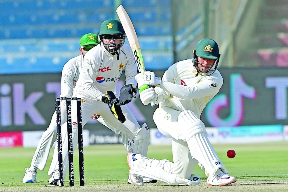 Australia's Usman Khawaja (R) plays a shot as Pakistan's wicketkeeper Mohammad Rizwan watches during the first day of the second Test at the National Stadium in Karachi. -- AFP