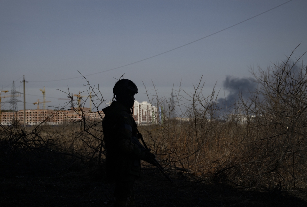 A Ukrainian soldier stands guard in Irpin, a town northwest of Kyiv where many of the few remaining civilians fled on Saturday with the sounds of heavy fighting in the distance, March 12, 2022. (Lynsey Addario/The New York Times)