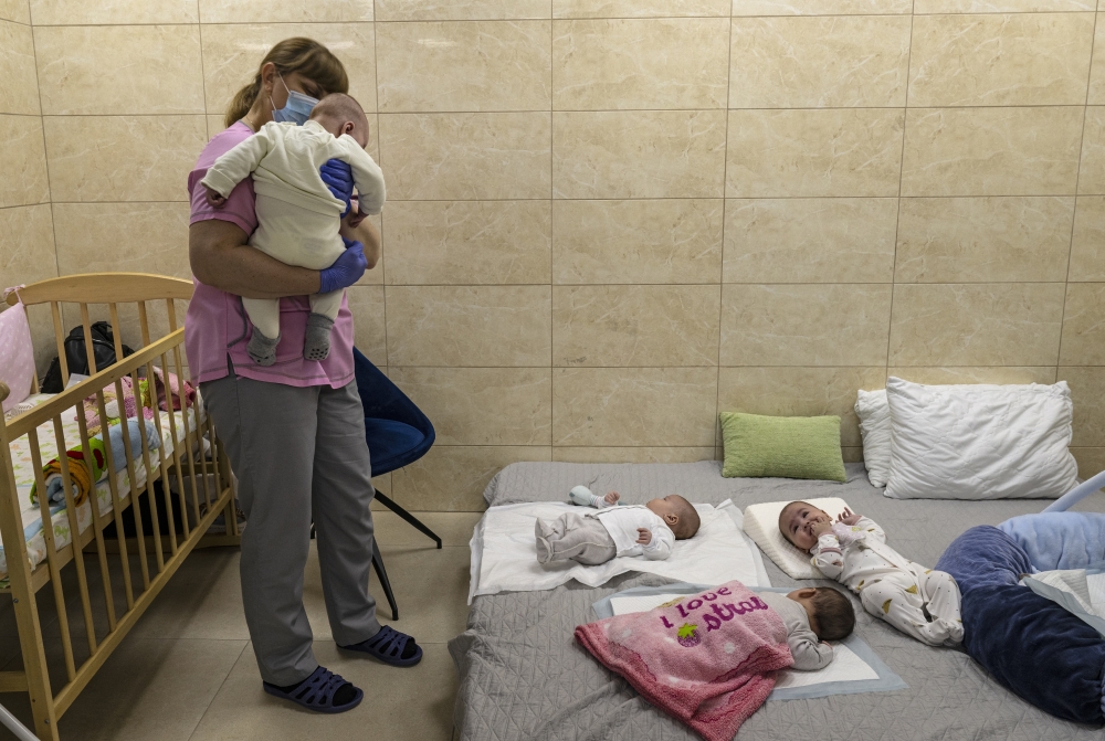 A nanny cares for babies born to Ukrainian surrogate mothers, now sheltered during the Russian invasion at a basement nursery in Kyiv, March 11, 2022. (Lynsey Addario/The New York Times)