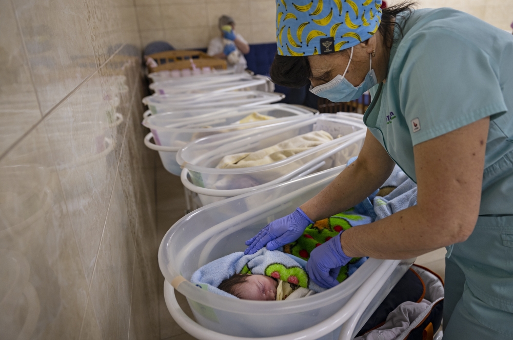 Svitlana Stetsiuk, 50, helps to care for one of 19 babies born to Ukrainian surrogate mothers, now sheltered during the Russian invasion at a basement nursery in Kyiv, March 11, 2022. (Lynsey Addario/The New York Times)