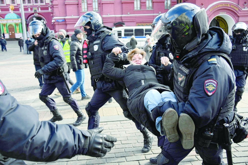Police officers detain a woman during a protest against Russian military action in Ukraine, in Manezhnaya Square in central Moscow. - AFP

