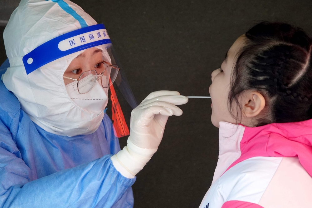 A child undergoes a nucleic acid test for the Covid-19 coronavirus in Yantai, in China's eastern Shandong province on March 14, 2022. 