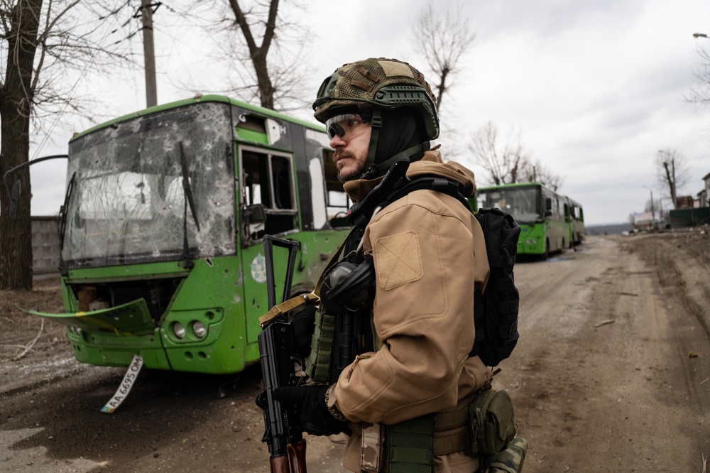 A Ukrainian soldier surveys destruction in the village of Horenka, near Kyiv, Ukraine, on Sunday, March 13, 2022. (Lynsey Addario/The New York Times)