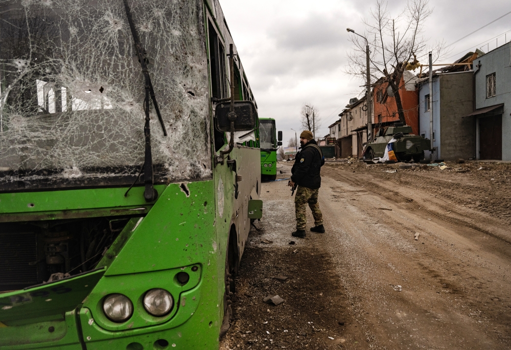 A Ukrainian soldier surveys destruction in the village of Horenka, near Kyiv, Ukraine, on Sunday, March 13, 2022. (Lynsey Addario/The New York Times)
