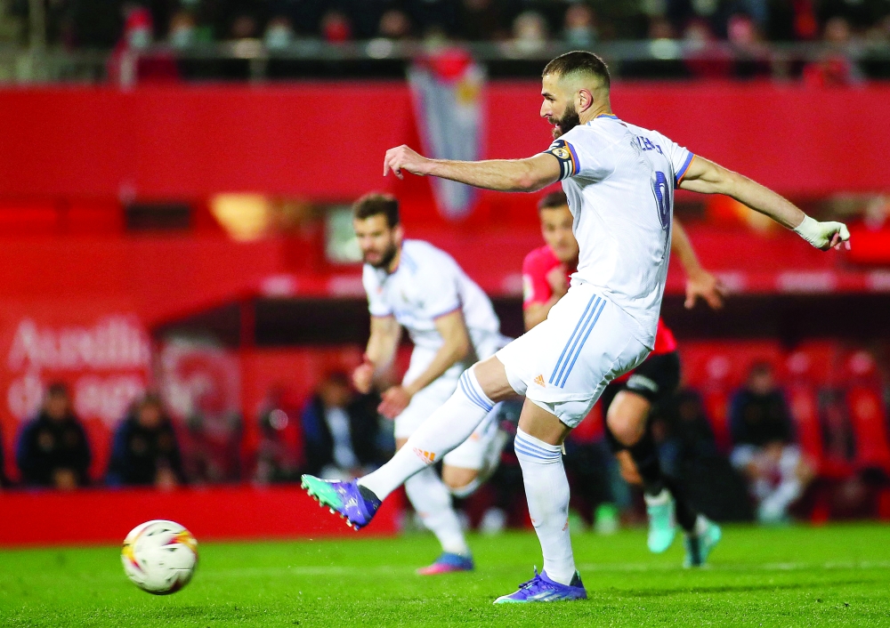 Real Madrid's Karim Benzema shoots and scores a a goal during the Spanish League match against Mallorca. -- AFP