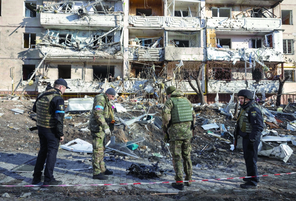 Ukraine soldiers inspect the rubble of a destroyed apartment building in Kyiv after strikes on residential areas killed at least two people. - AFP