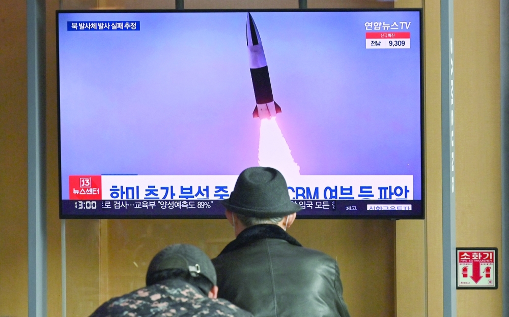 People watch a TV screen showing a news broadcast with file footage of a North Korean missile test, at a railway station in Seoul. - AFP

