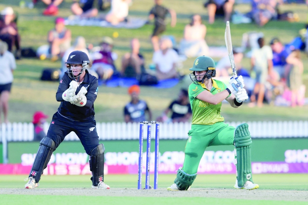 South Africa's Laura Wolvaardt plays a shot watched by New Zealand's wicketkeeper Katey Martin during the 2022 Women's Cricket World Cup match between New Zealand and South Africa at Seddon Park in Hamilton on March 17, 2022. (Photo by MICHAEL BRADLEY / AFP)