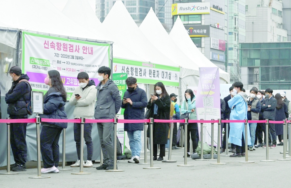 People wait in line to be tested for Covid-19 at a virus testing centre in Seoul. -- AFP