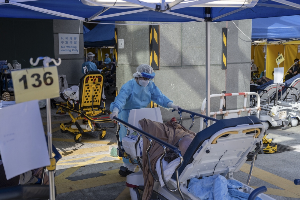 A healthcare worker transports a patient at the Caritas Medical Center hospital in Hong Kong, on Feb. 28, 2022. (Billy H.C. Kwok/The New York Times)