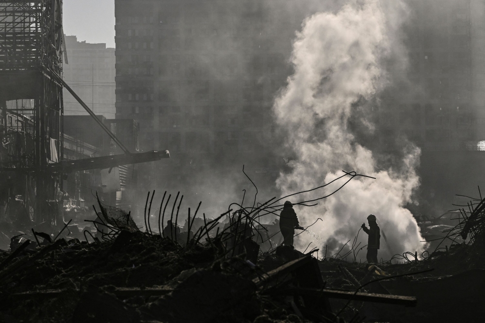 Firefighters douse the fire in the Retroville shopping mall after a Russian attack on the northwest of the capital Kyiv on March 21, 2022.