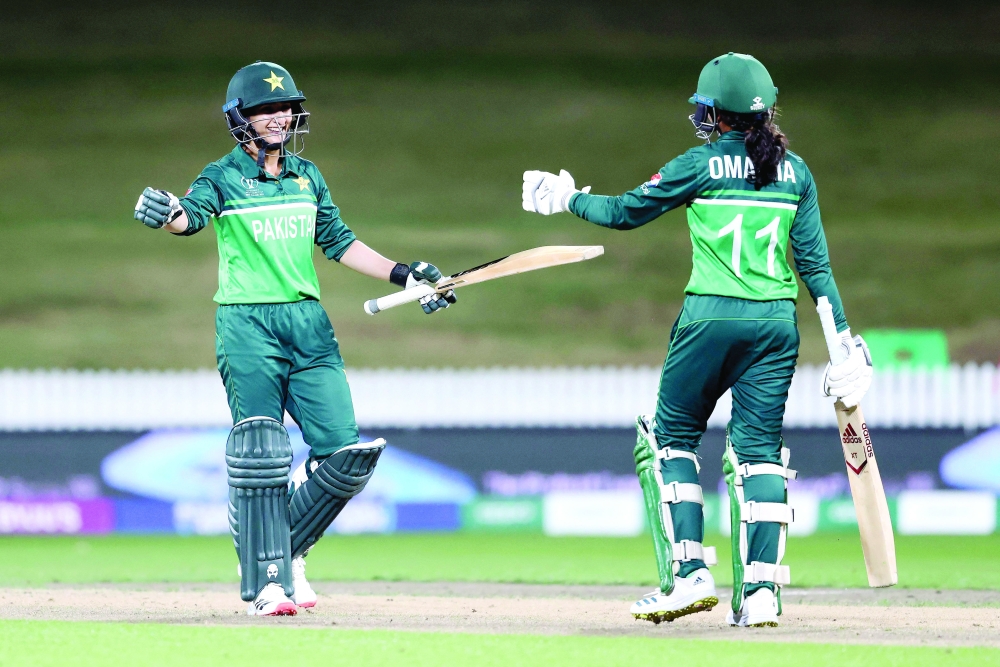 Pakistan's Bismah Maroof (L) and Omaima Sohail (R) celebrate winning the match during the 2022 Women's Cricket World Cup match between Pakistan and West Indies at Seddon Park in Hamilton on March 21, 2022. (Photo by MICHAEL BRADLEY / AFP)

