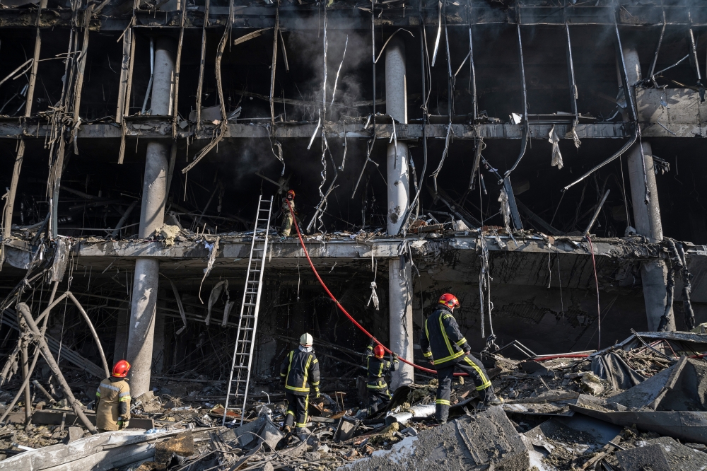 Firefighters and rescue workers on the scene after a Russian missile strike reduced a sprawling shopping mall in Kyiv to a smoldering ruin on Monday, March 21, 2022. (Lynsey Addario/The New York Times)